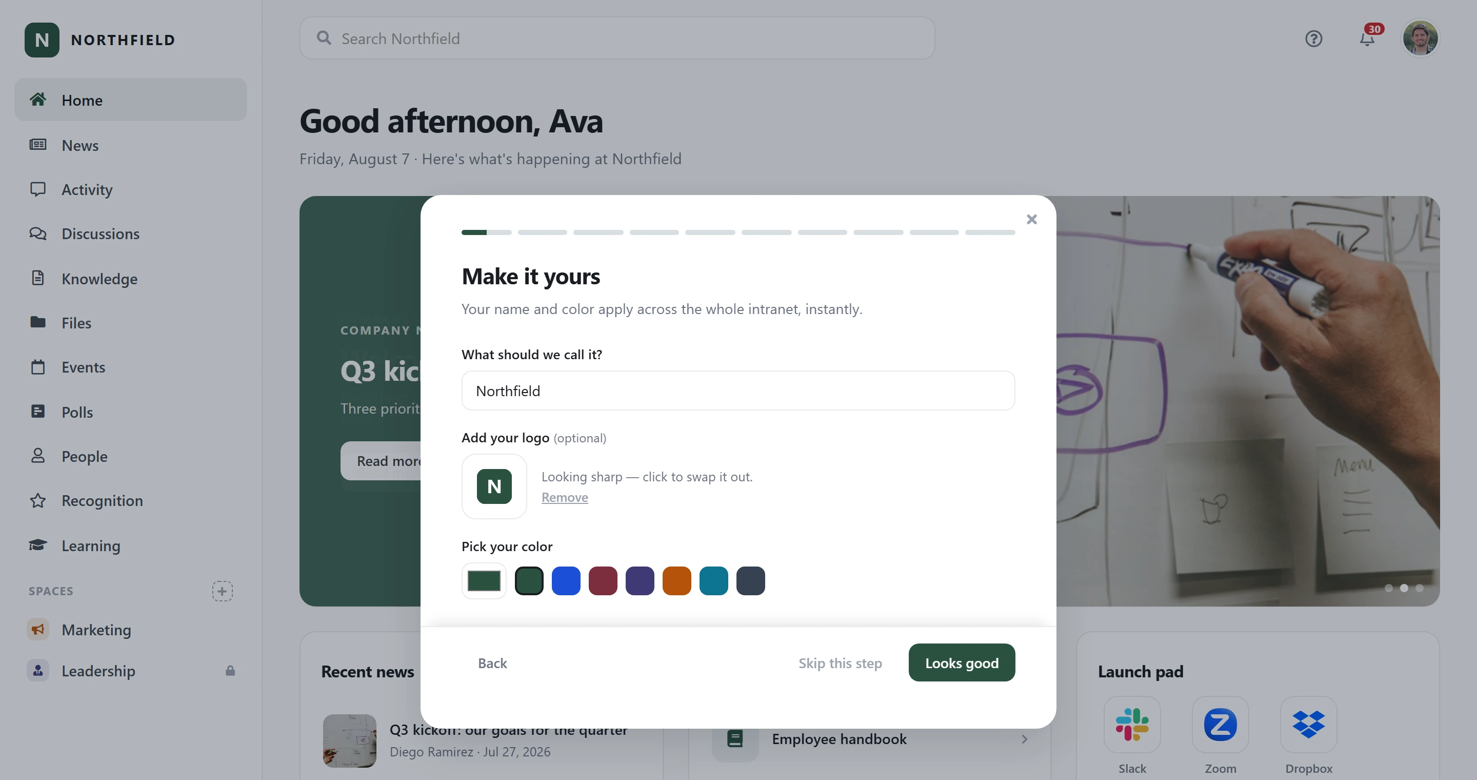 The Axero Go guided setup open over a company’s own home page: the wizard’s “Make it yours” step, with Northfield in the name field and a green N logo, over a Northfield-branded intranet — the same green N and wordmark in the sidebar, a dark-green featured story and a launch pad of app tiles behind the dialog.
